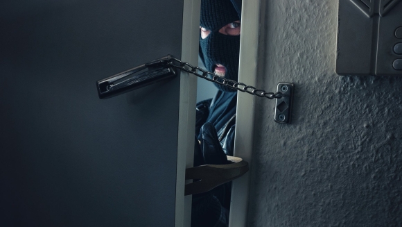 Грабитель взламывает дверь