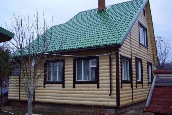 Обшивка дома с зеленой крышей